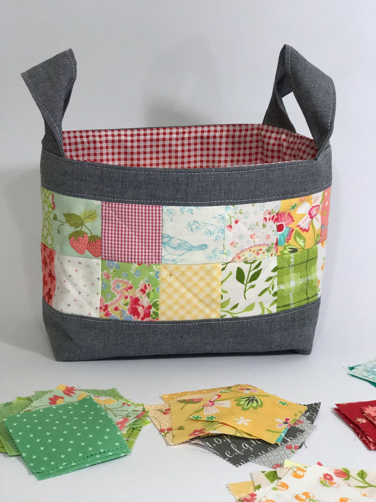 Cesto de patchwork en telas verdes y rojas con asas grises