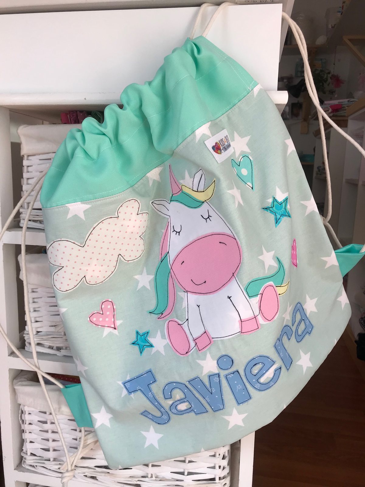 Morral celeste con un dinosaurio y el nombre Javiera
